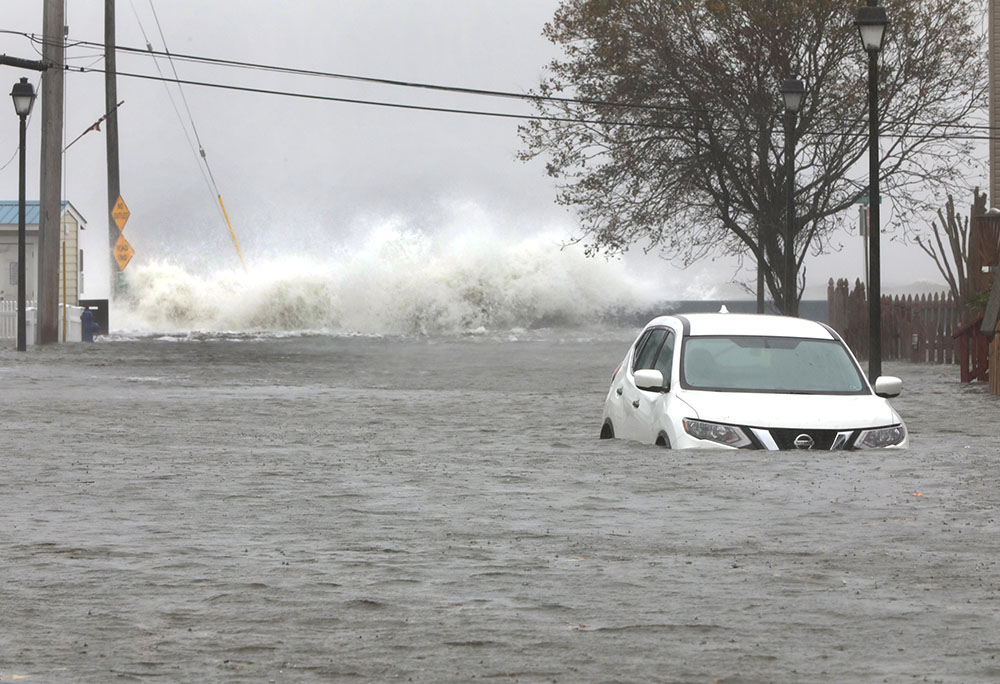 Waves crash over rocks near a submerged vehicle along Maryland's Chesapeake Bay during a Nor'easter in North Beach Oct. 29, 2021. (CNS/Bob Roller)