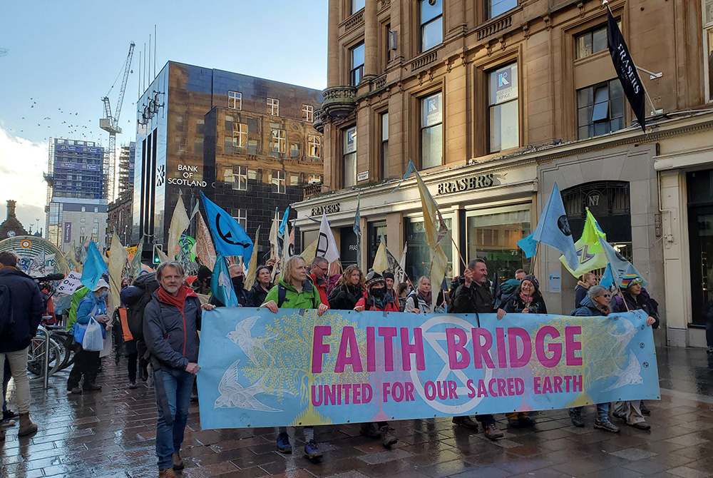 A group of interfaith climate pilgrims join hundreds of people processing into central Glasgow, Scotland, Oct. 30, ahead of the start COP26, the United Nations climate change conference. (EarthBeat photo/Brian Roewe) A group of interfaith climate pilgrims join hundreds of people processing into central Glasgow, Scotland, Oct. 30, ahead of the start COP26, the United Nations climate change conference. (EarthBeat photo/Brian Roewe)