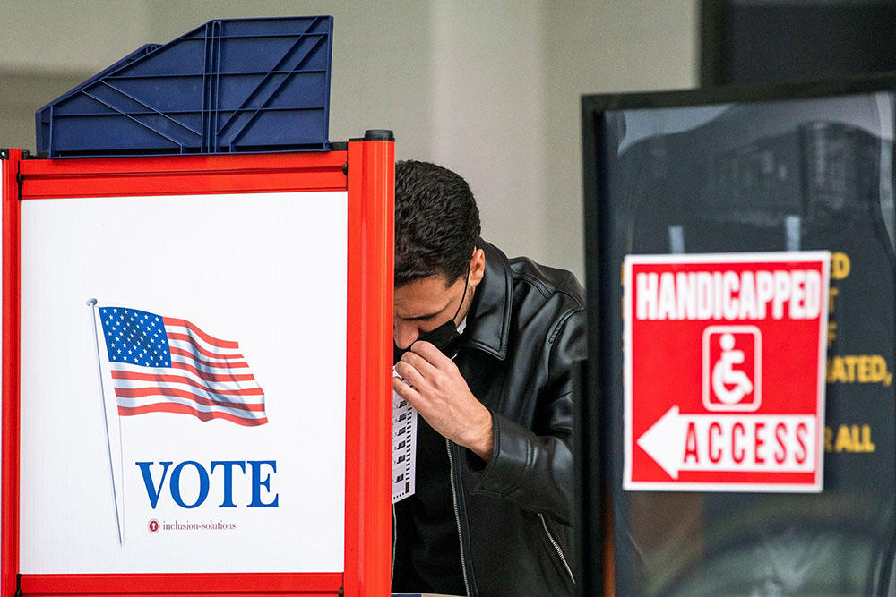 A man in Newark, New Jersey, fills in his ballot in a privacy booth while voting in the gubernatorial election Nov. 2. (CNS/Reuters/Eduardo Munoz)
