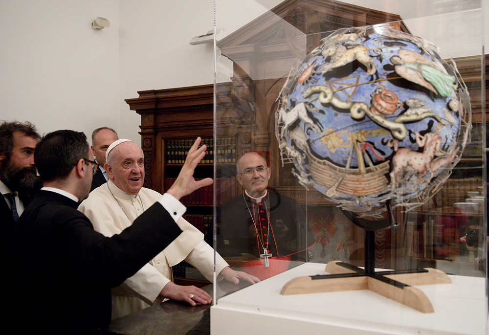 Pope Francis looks at a globe as he inaugurates a new permanent exhibition space in the Vatican Library Nov. 5, 2021. (CNS/Vatican Media)