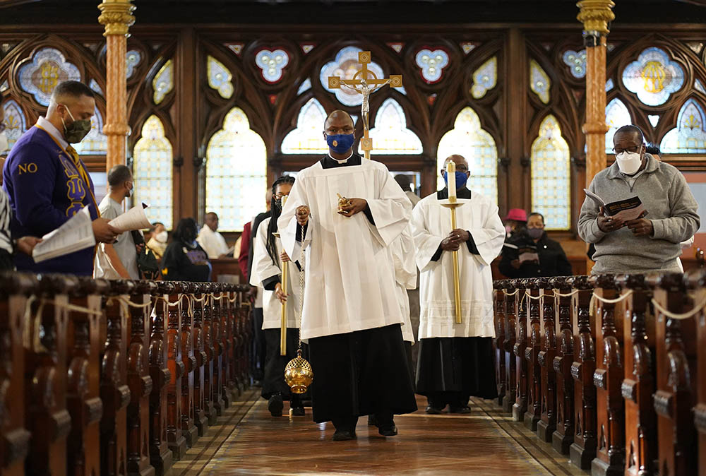 Toby Offiah, a seminarian of the Diocese of Brooklyn, New York, leads the opening procession during a Mass marking Black Catholic History Month Nov. 21, 2021, at Our Lady of Victory Church in the Bedford-Stuyvesant section of Brooklyn. (CNS)