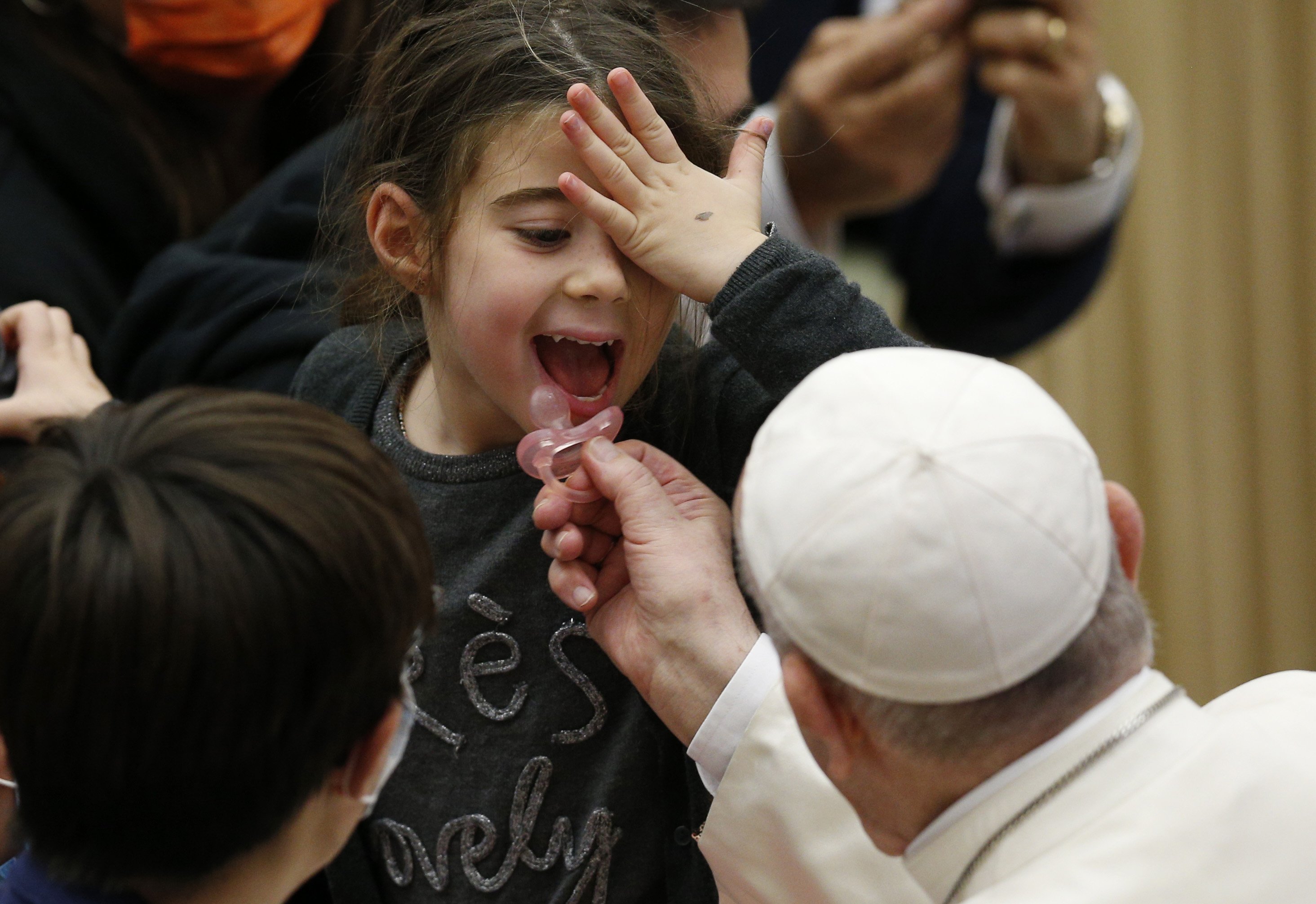 Pope Francis puts a pacifier into a child's mouth during his general audience in the Paul VI hall at the Vatican Nov. 24, 2021. (CNS photo/Paul Haring)