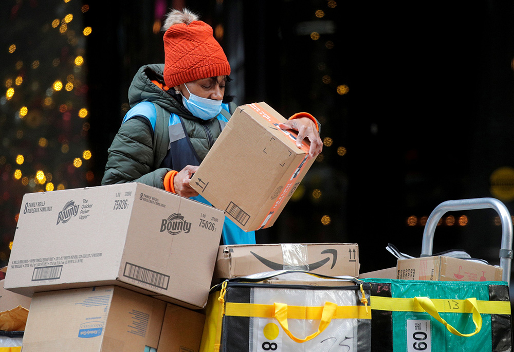 An Amazon delivery worker in New York City stacks boxes on Cyber Monday Nov. 29, 2021. (CNS/Reuters/Brendan McDermid)