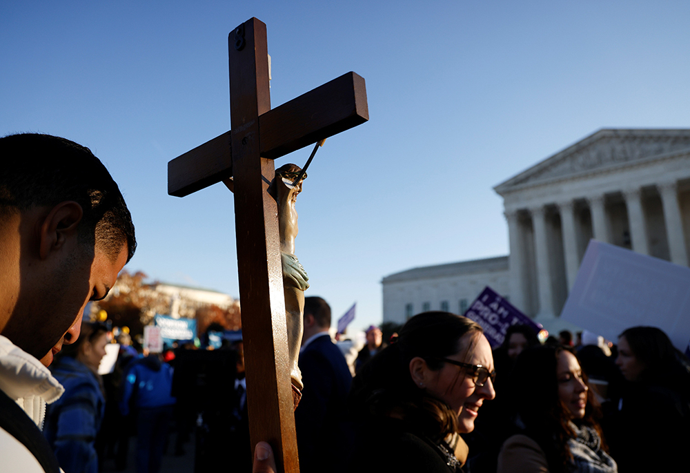 A pro-life activist holding a crucifix joins a protest outside the U.S. Supreme Court building Dec. 1, 2021, in Washington. (CNS/Reuters/Jonathan Ernst) A pro-life activist holding a crucifix joins a protest outside the U.S. Supreme Court building Dec. 1, 2021, in Washington. (CNS/Reuters/Jonathan Ernst)