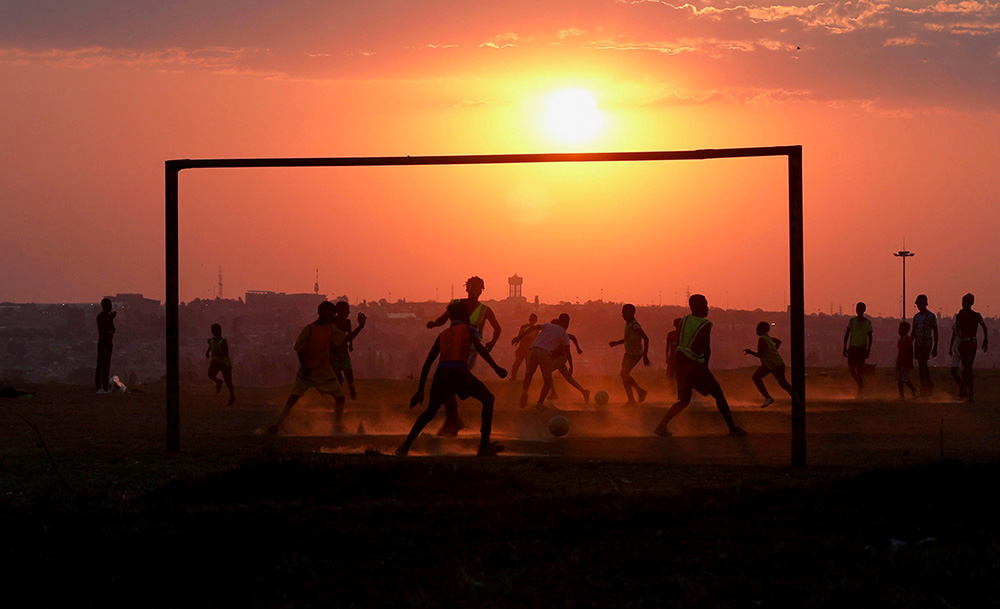 People play soccer on a dusty pitch in Soweto, South Africa, Sept. 15, 2021. (CNS/Reuters/Siphiwe Sibeko)