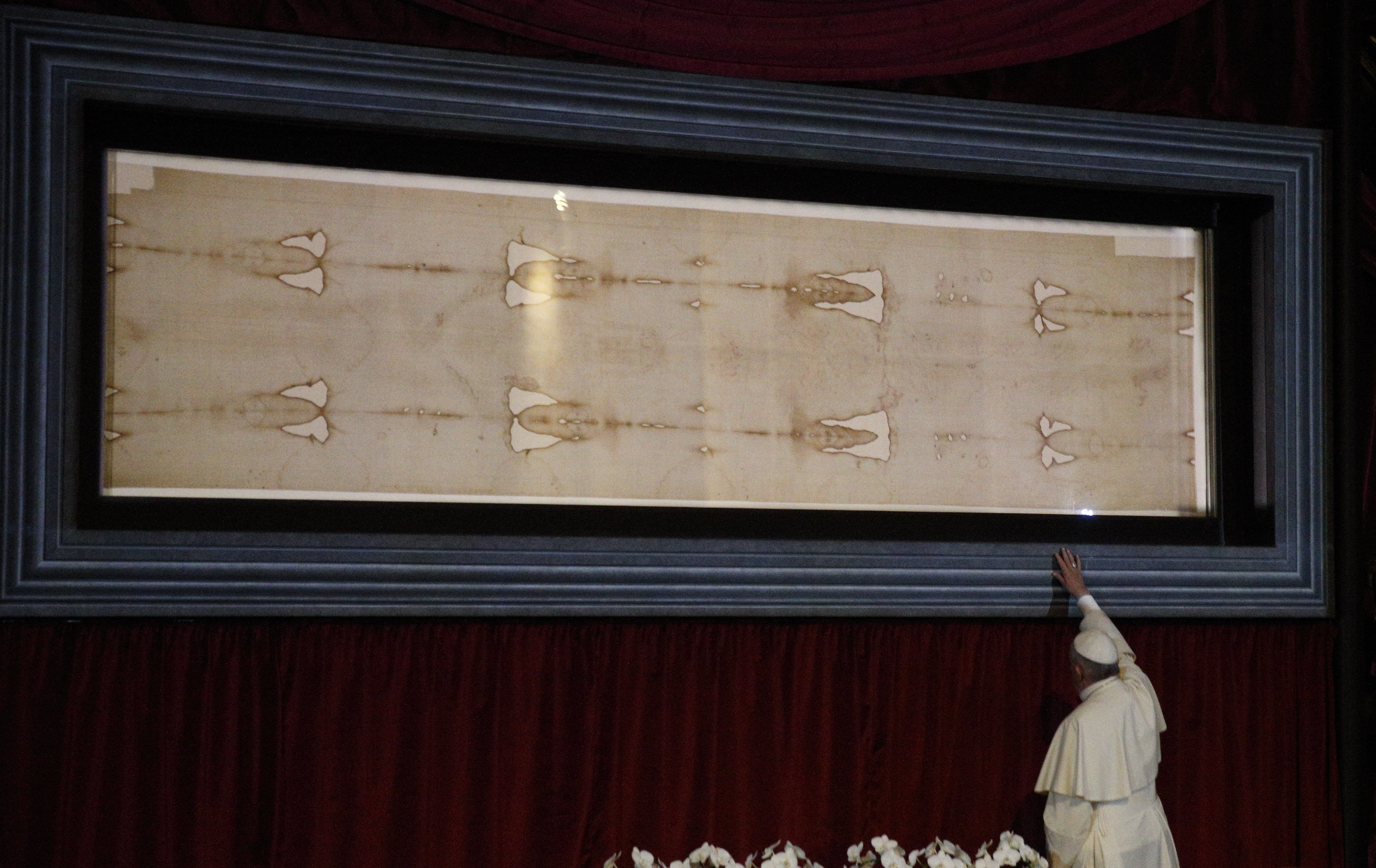 Pope Francis touches the case holding the Shroud of Turin after praying before the cloth in 2015 at the Cathedral of St. John the Baptist in Turin, Italy. (CNS photo/Paul Haring)