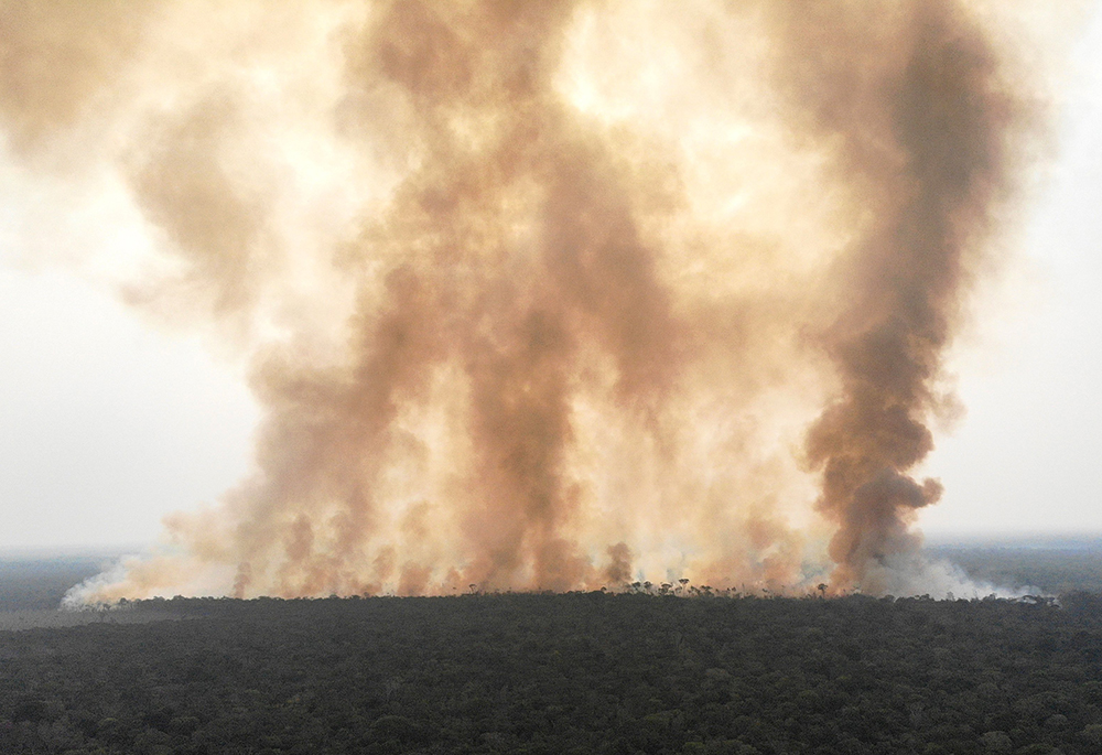 Smoke billows from a fire in August 2020 in an area of the Amazon jungle as it is cleared by loggers and farmers near Humaita, Brazil. (CNS photo/Reuters/Ueslei Marcelino)
