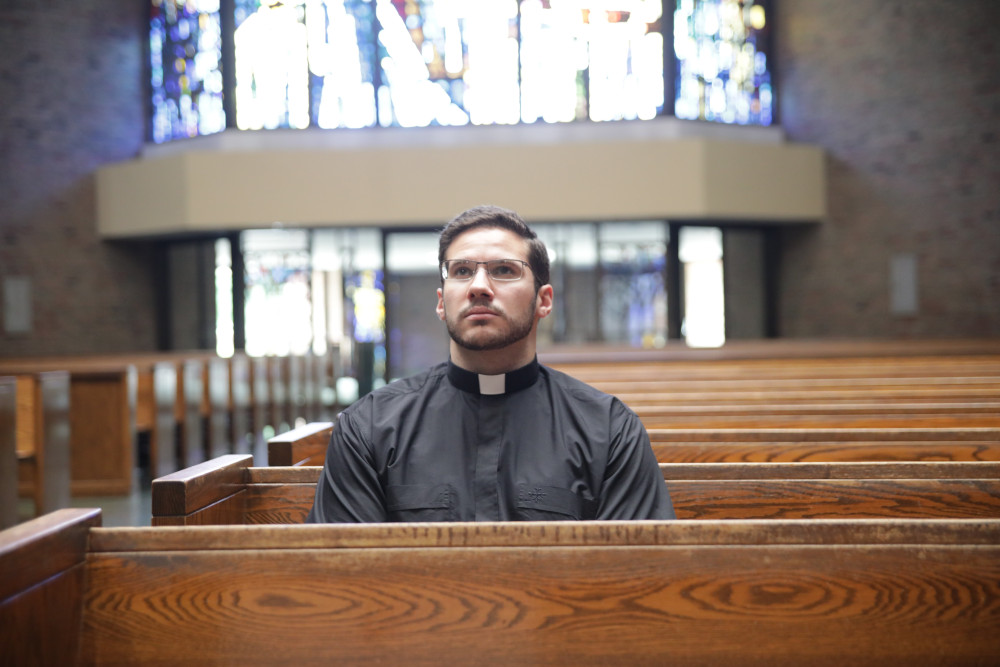 Deacon Jeremy Schupbach, a fourth-year seminarian who was assigned to St. Frances Cabrini Parish in Allen Park, Michigan, for the summer, sits in contemplation at the parish church July 27. (CNS/Detroit Catholic/Dan Meloy)