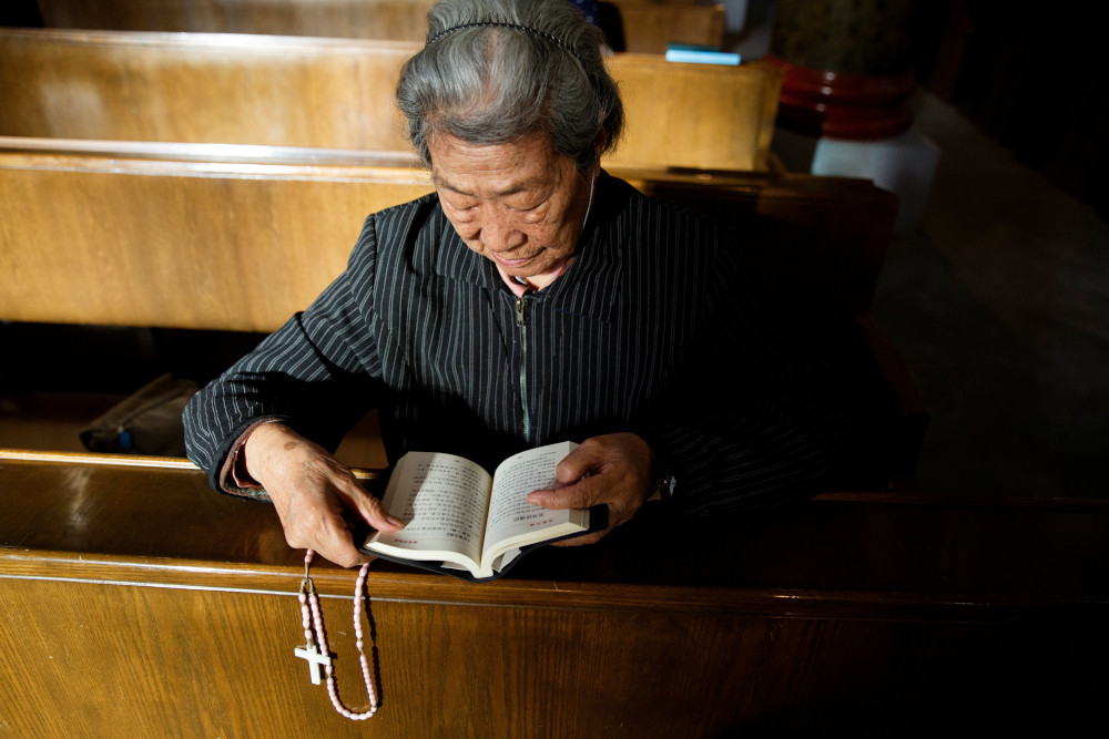 A person reads the Bible during Mass at St. Joseph's Church in Beijing