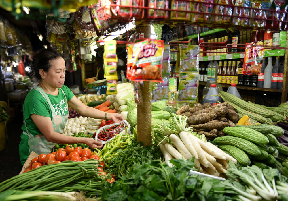 A vendor arranges her vegetables at a market in Manila, Philippines, in this 2018 file photo. A Philippine Catholic foundation will partner with the country's agriculture department to grow vegetables to feed the nation's poor communities. (CNS photo/Dondi Tawatao, Reuters)