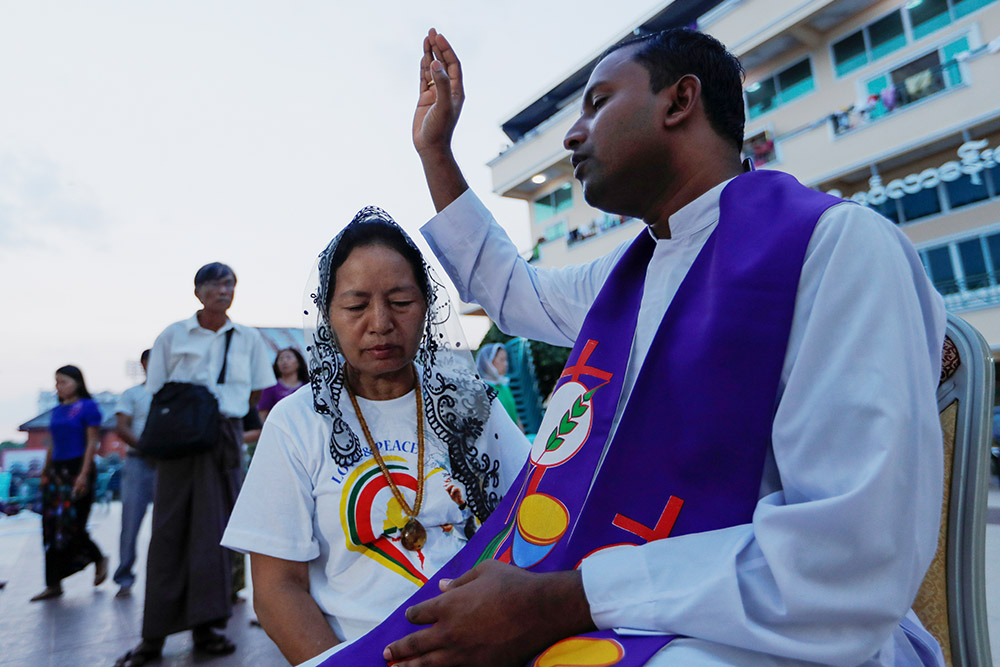 A woman offers her confession to a priest in front of St. Anthony Catholic Church in Yangon, Myanmar, Nov. 28, 2017. The issue of the role of women in the church came up repeatedly in listening sessions preparing for the Synod of Bishops on synodality. (CNS/Reuters/Jorge Silva)