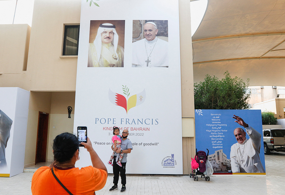 A visitor takes photo in front of a welcome banner Oct. 30 at Sacred Heart Catholic Church in Manama, Bahrain. The church is one of the places Pope Francis will visit during his Nov. 3-6 trip to Bahrain. (CNS/Reuters/Hamad I. Mohammed)