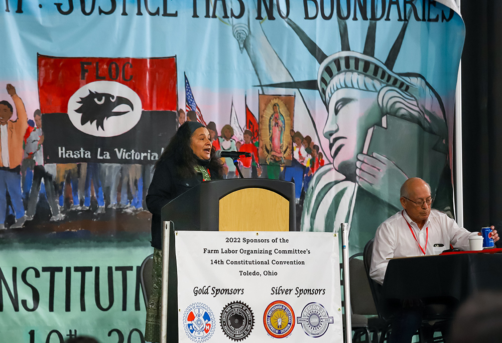 Leticia Zavala, a former vice president of the Farm Labor Organizing Committee, speaks during the group's convention in September in Toledo, Ohio, as Baldemar Velasquez, the group's president, sits on the dais. (Matt Emmick)