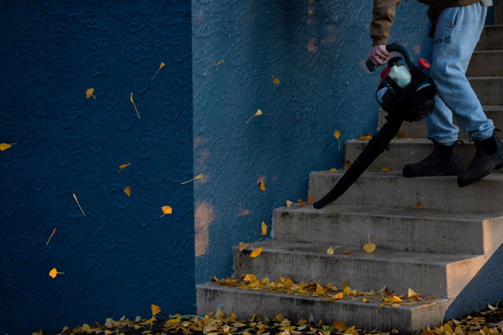 Person with leaf blower clears stairs