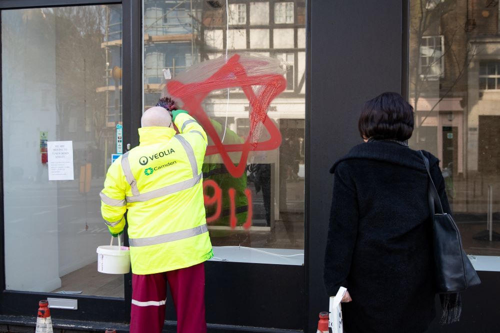 A worker removes antisemitic graffiti on a shop window in the Belsize Park neighborhood of London Dec. 29, 2019. (CNS/Reuters/Aaron Chown)