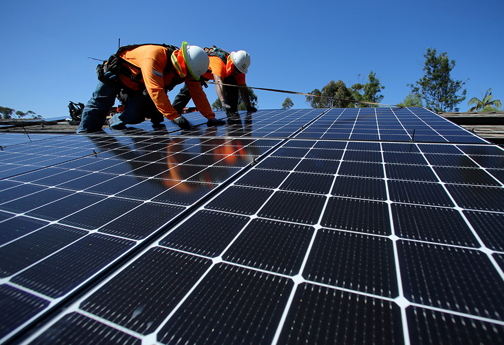 Solar installers are seen on a residential home Oct. 14, 2016, in Scripps Ranch, California. (CNS/Reuters/Mike Blake)