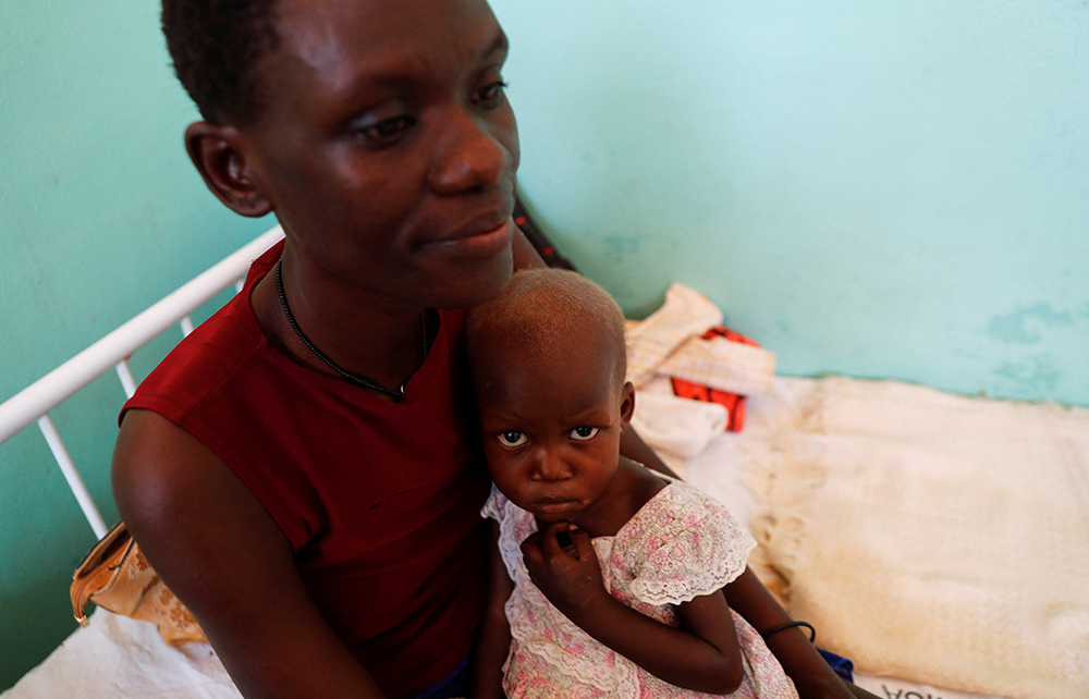 A woman holds her severely malnourished son at a hospital in Lodwar, Kenya, Sept. 26. (CNS/Reuters/Thomas Mukoya)