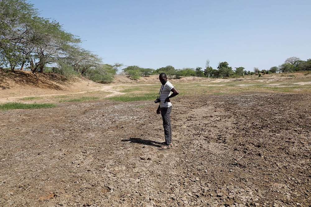 Scientist Chris Shitote examines a dry water hole in Kilifi, Kenya, Feb. 16. (CNS/Reuters/Baz Ratner)