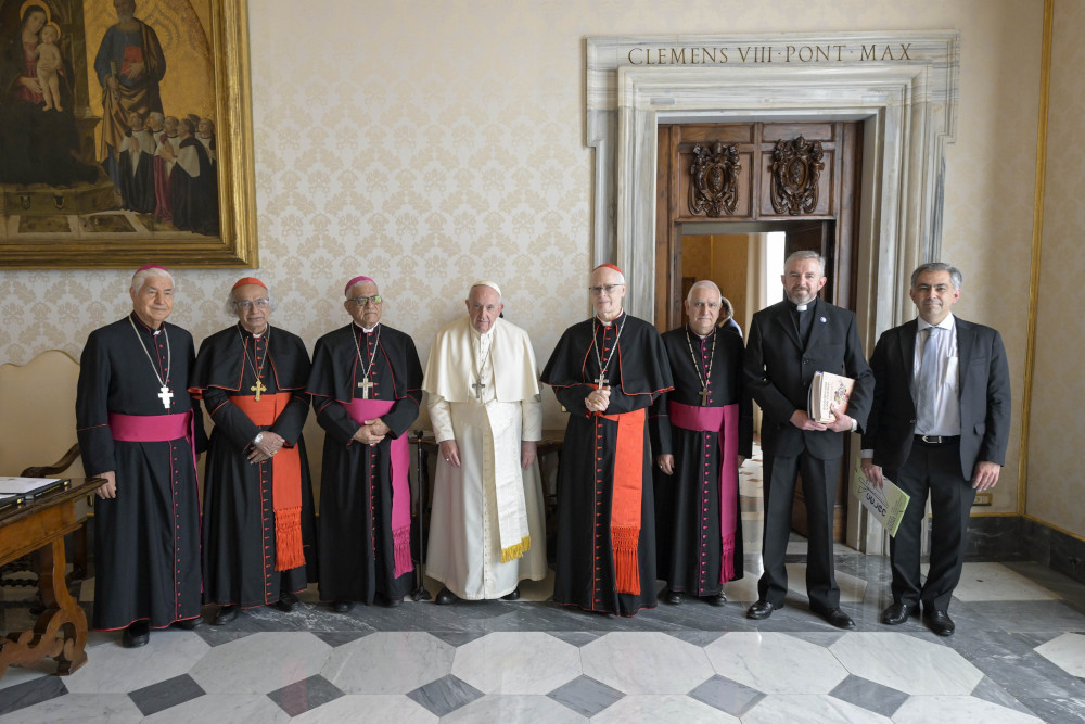 Pope Francis poses for a photo with leaders of the Latin American bishops' council, or CELAM, in the library of the Apostolic Palace at the Vatican Oct. 31, 2022.