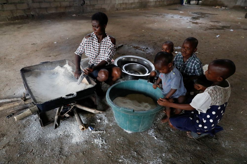 A woman displaced by flooding cooks food for her family at a school converted to relief camp in Ogbogu, Nigeria, Oct. 21, 2022. (CNS/Reuters/Temilade Adelaja)