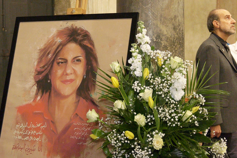 A portrait of Shireen Abu Akleh stands alongside flowers on Oct. 26 at the entrance of the Basilica of Santa Maria in Cosmedin, historically considered the home church for Catholics practicing in the Greek Melkite rite in Rome. (Rome Reports/Justin McLellan)