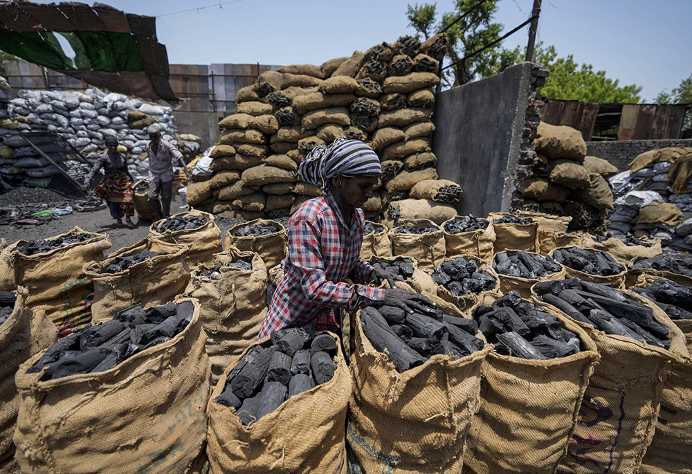 A woman works at a coal depot May 2 in Ahmedabad, India. (AP photo/Ajit Solanki, File)