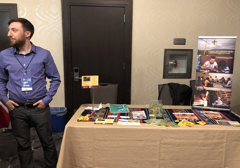 A former Rostro de Cristo volunteer stands at the Rostro de Cristo table at the at the Ignatian Family Teach-In for Justice in Washington, D.C., Oct. 23. (NCR photo/Aleja Hertzler-McCain)