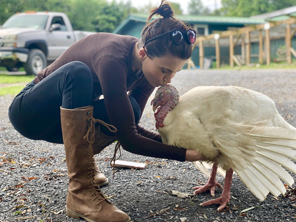 Veronica Finnegan, communications manager of Catskill Animal Sanctuary in Saugerties, New York, shares a tender moment with Michael the turkey, rescued from the street outside a local turkey farm just before Thanksgiving. (Courtesy of Catskill Animal Sanctuary)