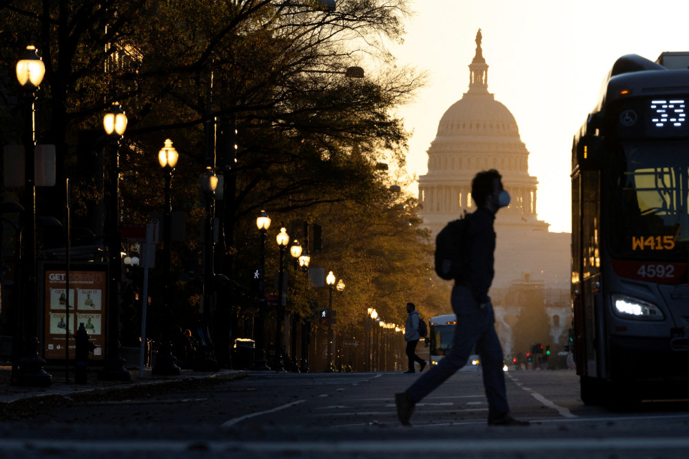 A pedestrian crosses Pennsylvania Avenue as the sun rises over the U.S. Capitol in Washington Nov. 9. (CNS/Reuters/Tom Brenner)