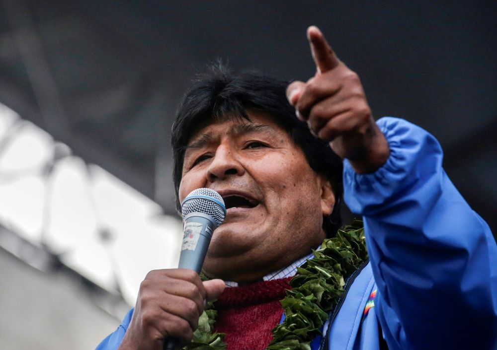 Former president of Bolivia, Evo Morales, speaks into a microphone and gestures.
