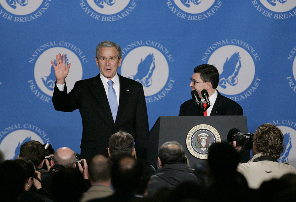 Then-President George W. Bush waves as he arrives at the fourth annual National Catholic Prayer Breakfast April 13, 2007, in Washington. The president was introduced by Leonard Leo, right, then-executive vice president of the Federalist Society for Law and Public Policy Studies. (CNS/Paul Haring)