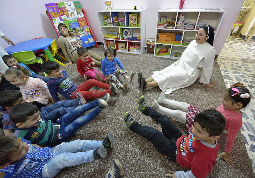 Sr. Ferdos Zora sings with students in a preschool for displaced children in Ankara, Iraq, April 7, 2016. The Dominican Sisters of St. Catherine of Siena were displaced by the Islamic State group in 2014 and have established schools and other ministries among the displaced. (CNS/Paul Jeffrey)