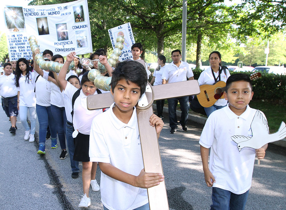 Jesus Solorio carries a cross during a Eucharistic Congress procession June 17, 2017, in College Park, Georgia, in the Atlanta Archdiocese. (CNS/Georgia Bulletin/Michael Alexander)