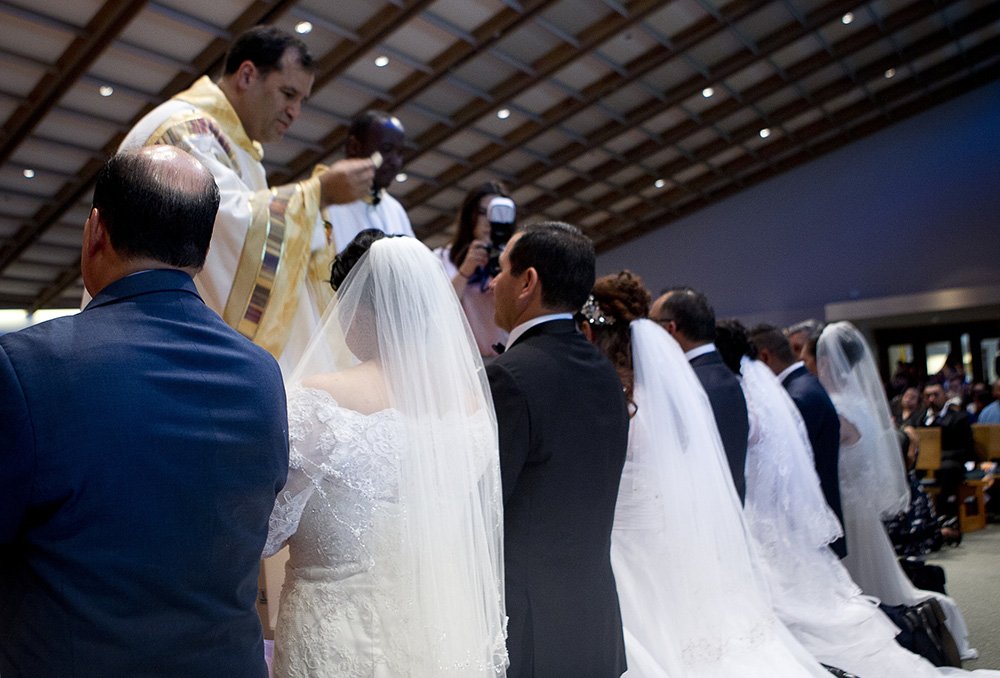 Maria and Arturo Perez receive Communion for the first time as a couple during their convalidation ceremony at Good Shepherd Catholic Church in Alexandria, Virginia, June 24, 2017. They joined other couples blessing their civil union. (CNS/Tyler Orsburn)