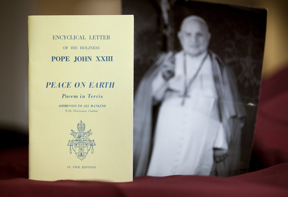 An early edition of the encyclical Pacem in Terris ("Peace on Earth") is pictured next to a photo of its author, Pope John XXIII. The landmark papal letter addressing universal human rights and relations between states was issued in 1963. (CNS/Nancy Wiechec)