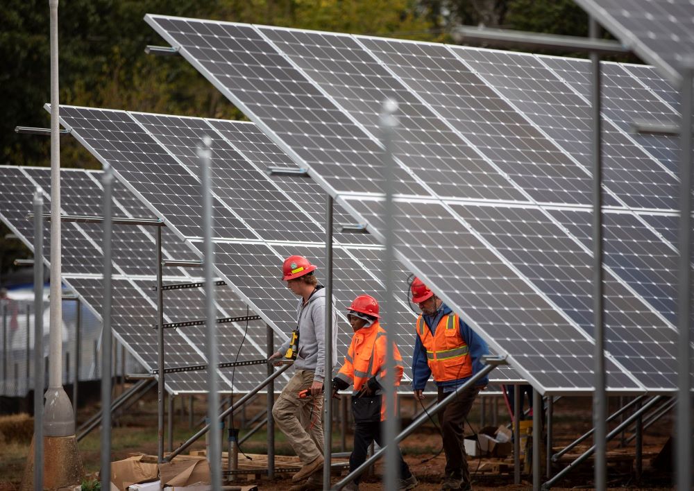 Workers in Washington are seen near solar panels Oct. 17, 2019, on the property of Catholic Charities of the Archdiocese of Washington. (CNS/Catholic Standard/Andrew Biraj)
