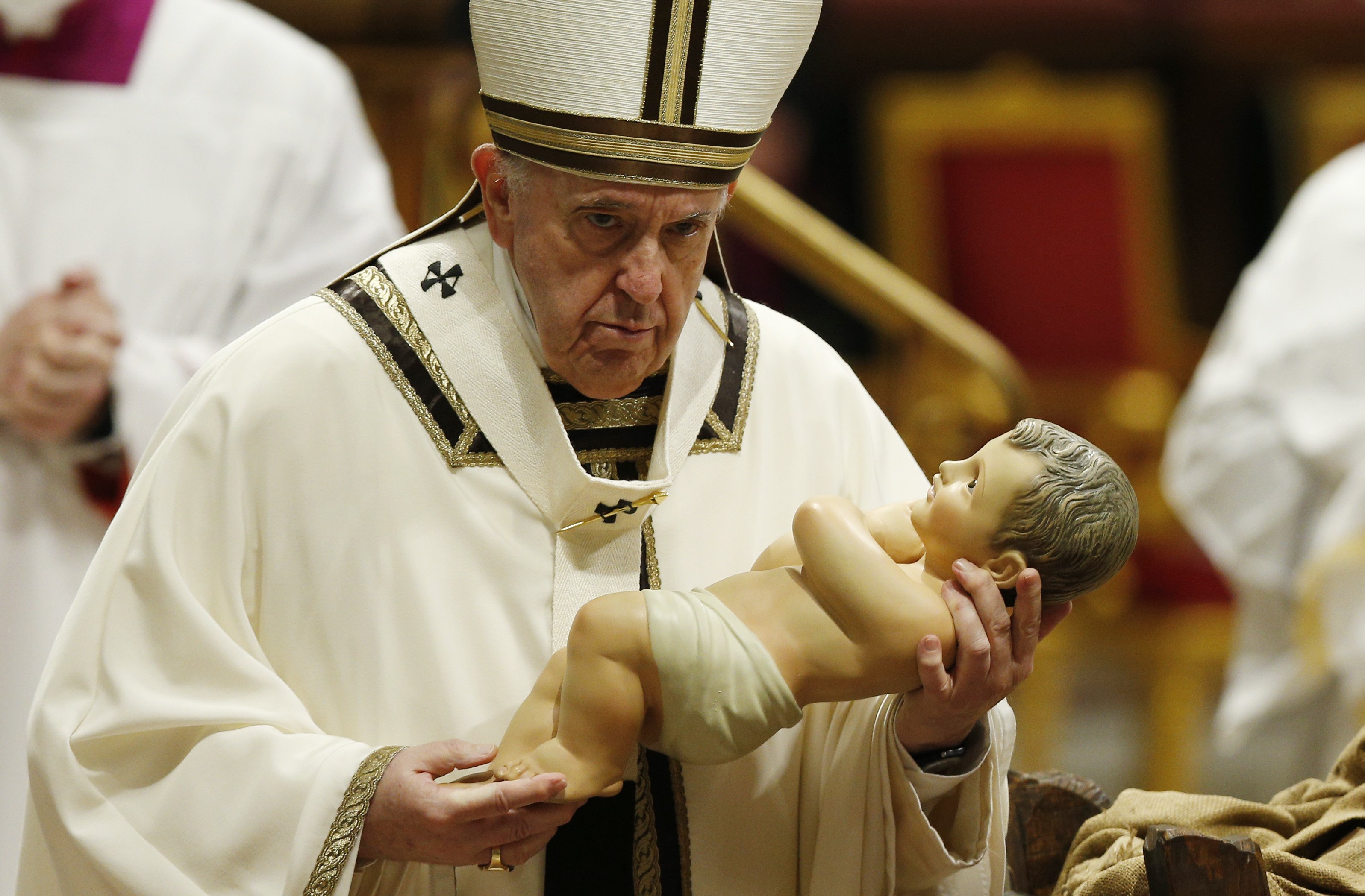 Pope Francis carries a figurine of the baby Jesus at the conclusion of Christmas Eve Mass in St. Peter's Basilica at the Vatican in this Dec. 24, 2021, file photo. (CNS/Paul Haring)