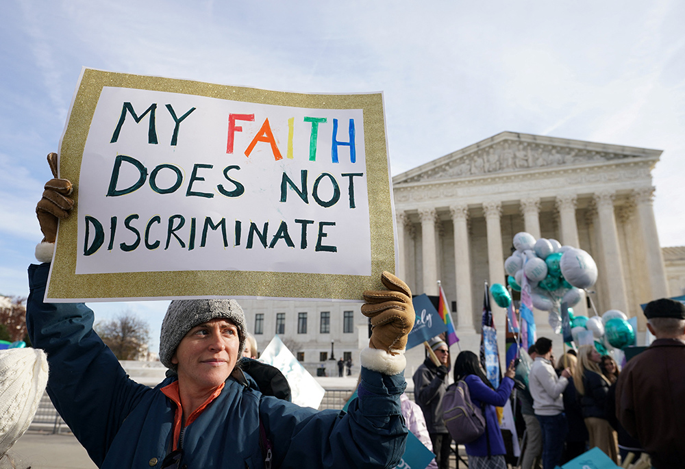 A protester displays a sign during a demonstration outside the U.S. Supreme Court Dec. 5 in Washington, as justices hear arguments in the case of a Colorado website designer who refuses to create websites for same-sex marriages due to her Christian beliefs about traditional marriage. (CNS/Reuters/Kevin Lamarque)