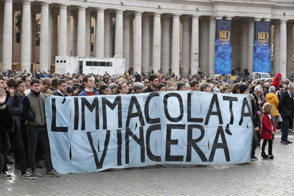 A group of people in St. Peter's Square holds banner that reads "L'Immacolata Vincera"