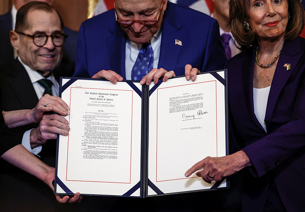 Rep. Jerry Nadler D-New York, left, Senate Majority Leader Chuck Schumer, D-New York, and House Speaker Nancy Pelosi, D-California, hold the Respect for Marriage Act during a bill enrollment ceremony on Capitol Hill in Washington Dec. 8, 2022. (CNS/Reuters/Evelyn Hockstein)