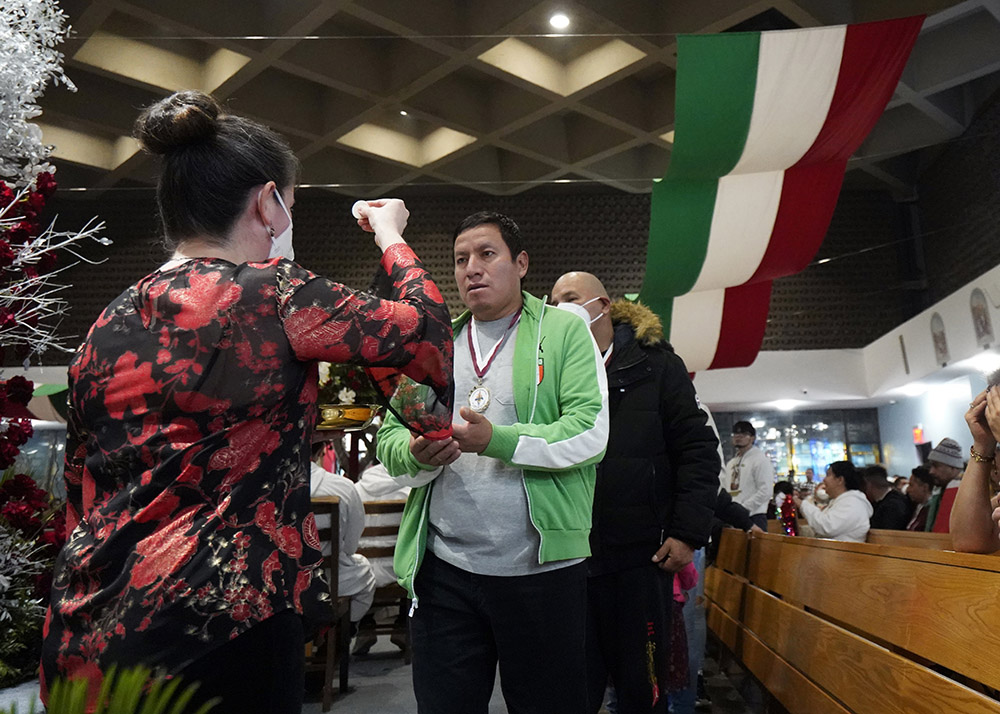 Worshippers receive Communion during a Spanish-language Mass celebrated on the eve of the feast of Our Lady of Guadalupe at Our Lady of Mount Carmel Church in Staten Island, New York, Dec. 11. Our Lady of Mount Carmel-St. Benedicta-St. Mary of the Assumption Parish ministers to a large population of immigrants from Mexico. (CNS/Gregory A. Shemitz)