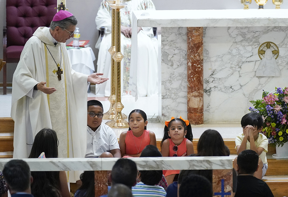 San Antonio Archbishop Gustavo García-Siller talks with children as President Joe Biden and first lady Jill Biden attend Mass at Sacred Heart Catholic Church May 29 in Uvalde, Texas, after the murder of 19 children and two teachers in an elementary school shooting May 24 in Uvalde. (AP photo/Evan Vucci)