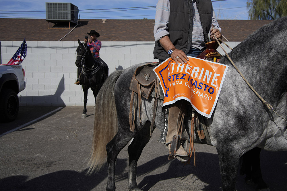 A supporter on horseback has a sign for Sen. Catherine Cortez Masto, D-Nevada, at a horse parade to get out the vote Nov. 5, 2022, in Las Vegas. (AP/John Locher)