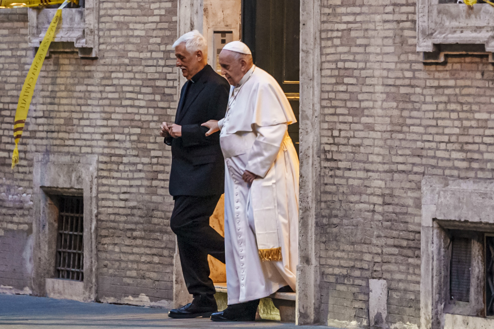 Pope Francis is flanked by the Jesuits superior general Fr. Arturo Sosa, left, as he leaves the Church of the Gesu', mother church of the Society of Jesus (Jesuits), after presiding at a mass on March 12, 2022. (AP Photo/Domenico Stinellis)