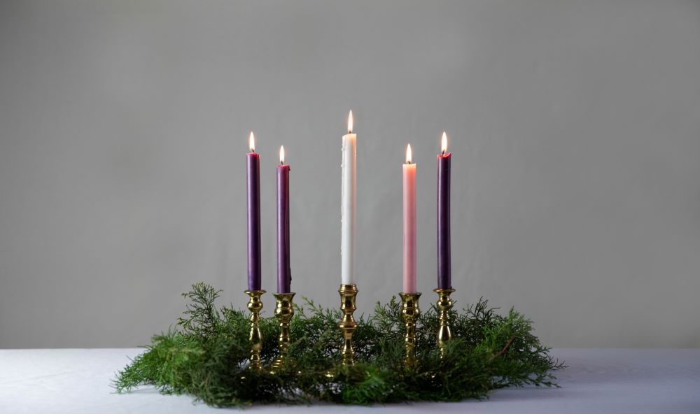 An advent wreath with all candles lit. (Unsplash/KaLisa Veer)