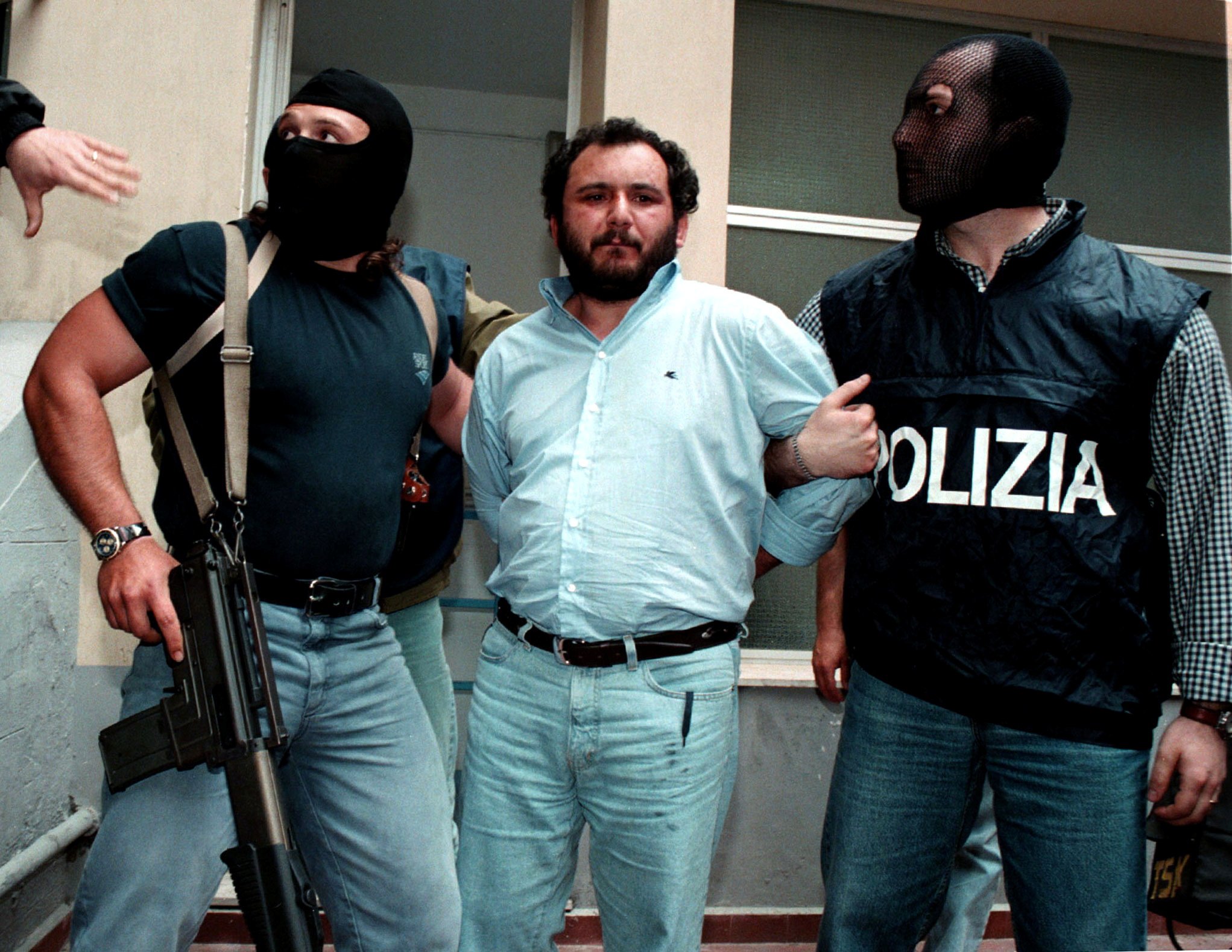 Anti-Mafia police, wearing masks to hide their identity, escort top Mafia fugitive Giovani Brusca as he leaves Palermo's police headquarters to be taken to a maximum security prison, in Palermo, Italy, in this May 21, 1996, file photo.