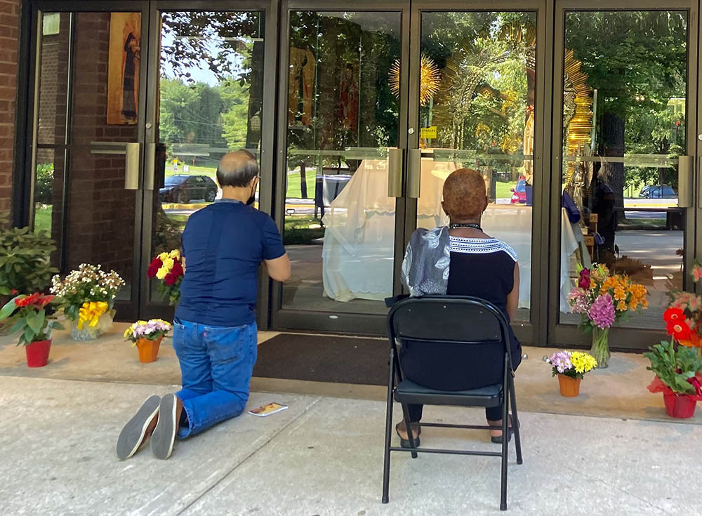 Two people pray before the Blessed Sacrament Aug. 11, 2021, at an adoration chapel, modified during the coronavirus pandemic, at St. John Neumann Catholic Church in Gaithersburg, Maryland. (CNS/Carol Zimmermann)