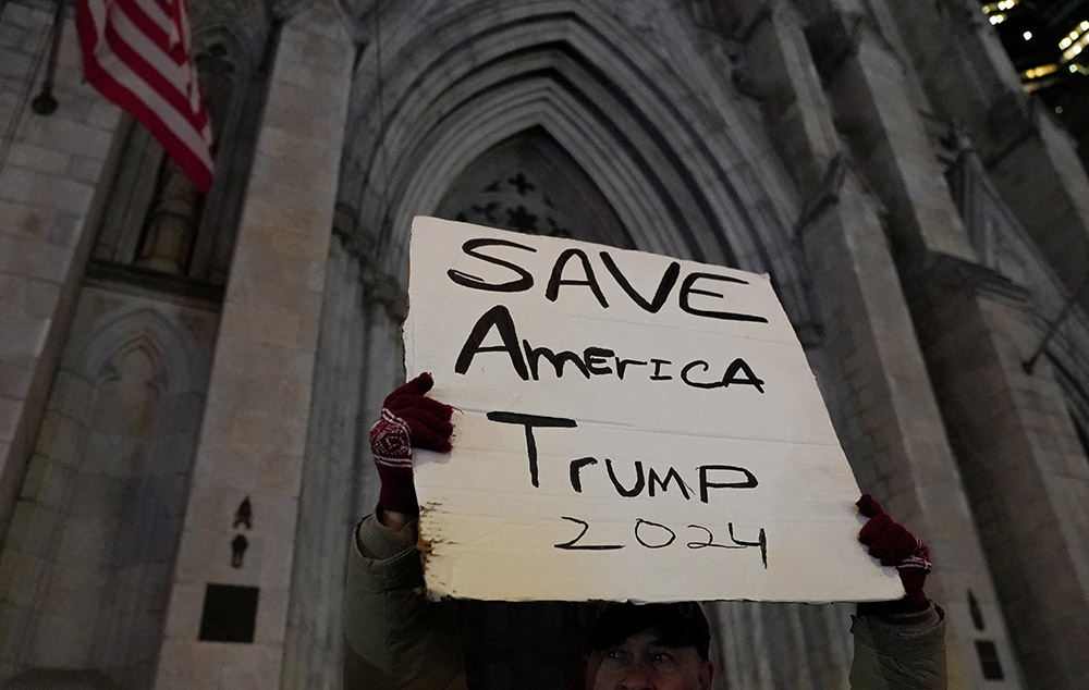 A person in New York City is seen during a candlelight vigil outside St. Patrick's Cathedral Jan. 6, 2022, the first anniversary of the attack on the U.S. Capitol by supporters of former President Donald Trump. (CNS/Reuters/David Dee Delgado)