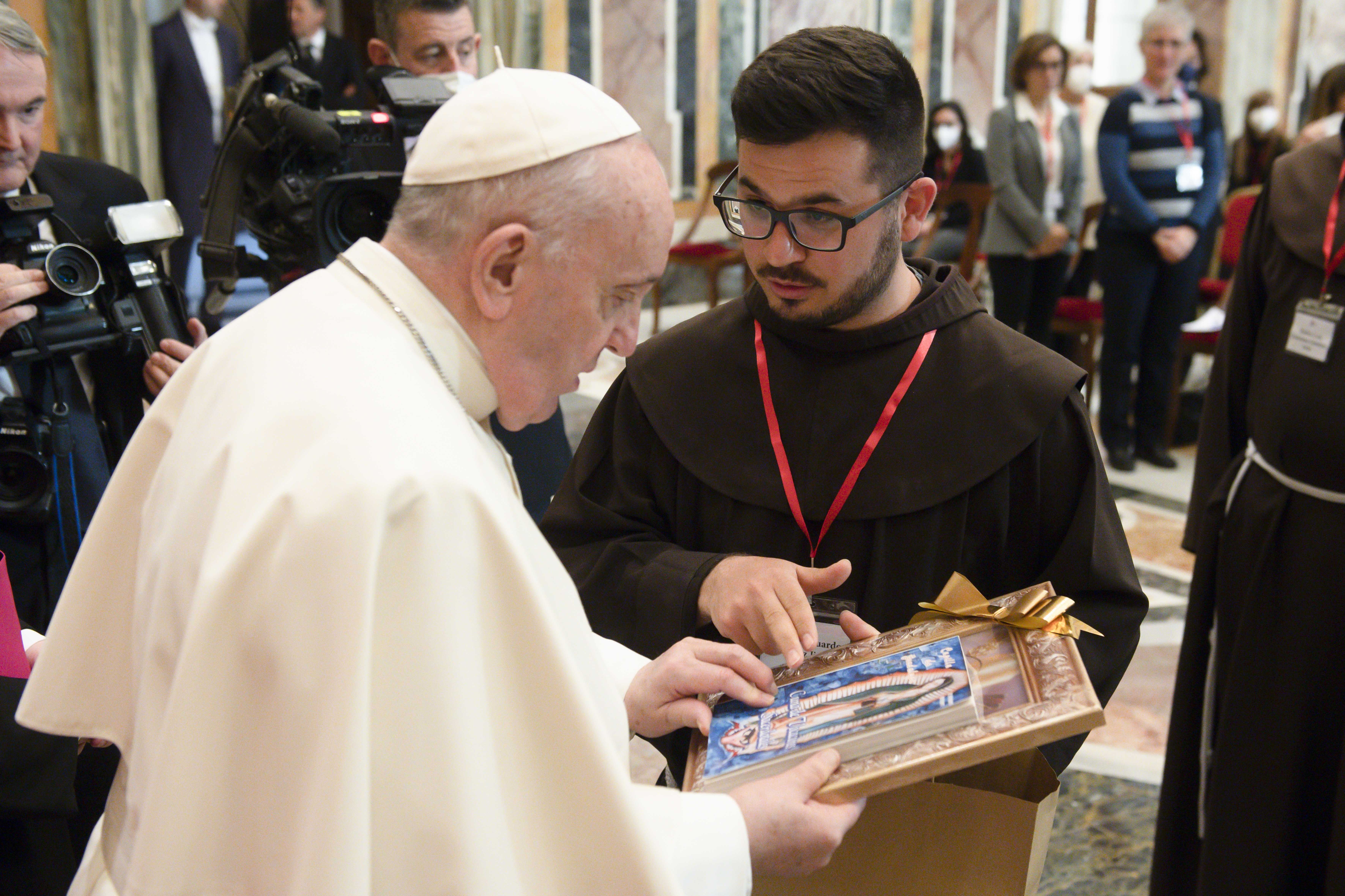 Pope Francis accepts a gift from a Franciscan friar during an audience with a delegation of communicators from the Custody of the Holy Land at the Vatican Jan. 17, 2022. (CNS photo/Vatican Media)