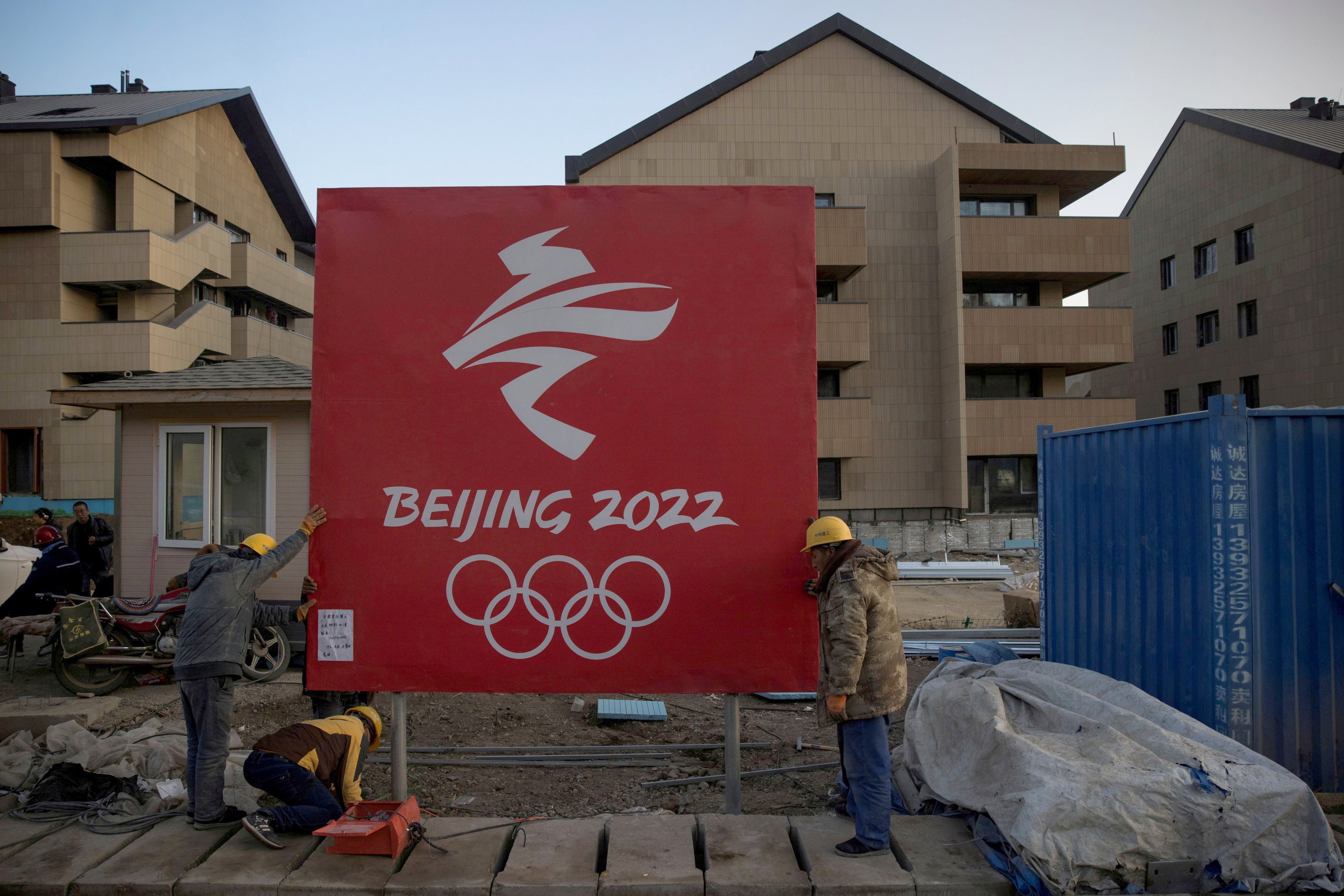 Workers move a sign Oct. 29, 2020, at the Thaiwoo ski resort near skiing venues of the 2022 Winter Olympics in Chongli, a popular ski resort town in China. (CNS photo/Thomas Peter, Reuters)